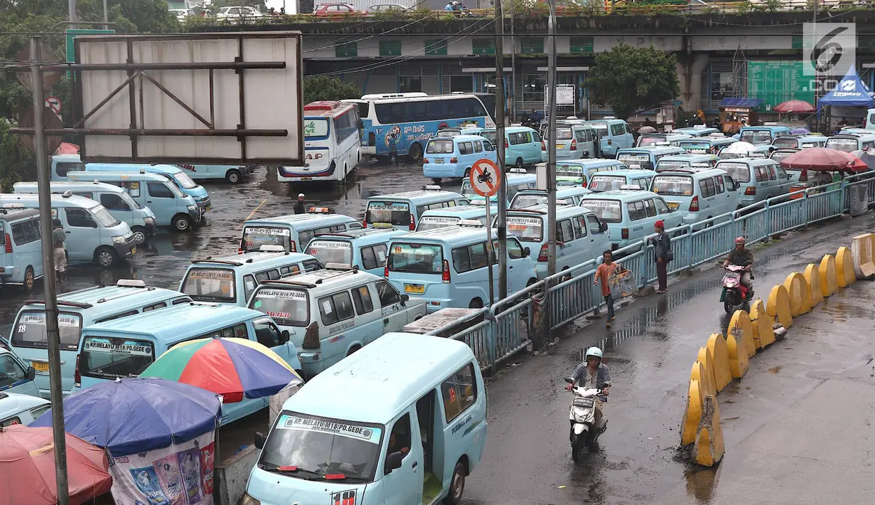 Pengendara sepeda motor melintasi jalur angkutan umum di Terminal Kampung Melayu, Jakarta, Rabu (6/2). Sejumlah pengendara nekat menerobos masuk terminal untuk memotong jalur guna memersingkat waktu tempuh. (Liputan6.com/Immanuel Antonius)