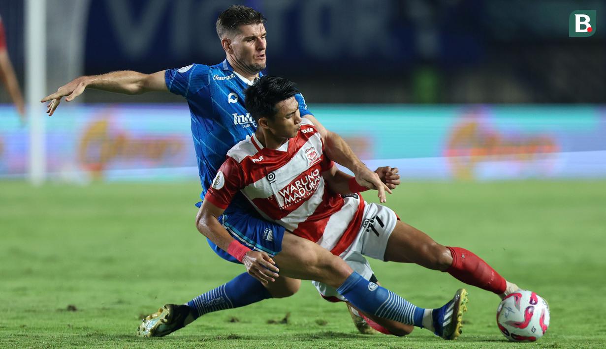 <p>Pemain Persib Bandung, Nick Kuipers (kiri) berebut bola dengan pemain Madura United, Malik Risaldi pada laga leg 1 final Championship Series BRI Liga 1 2023/2024 antara Persib Bandung melawan Madura United di Stadion Si Jalak Harupat, Bandung, Minggu (26/05/2024). (Bola.com/M Iqbal Ichsan)</p>