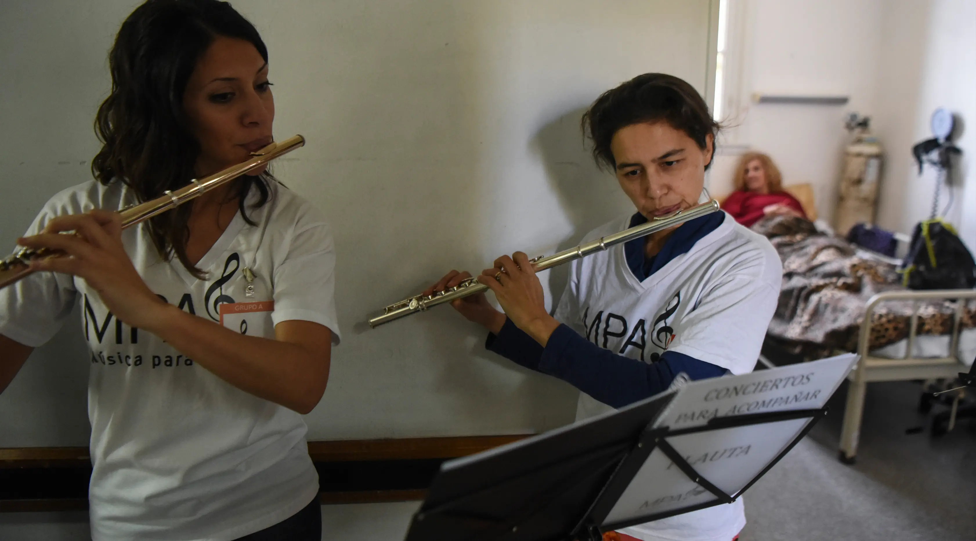 Dua orang relawan dari Musica Para el Alma memainkan alat musiknya di Rumah Sakit Alvarez di Buenos Aires, Argentina (12/6). Mereka juga sering tampil di sekolah pendidikan khusus, panti jompo dan institusi publik lainnya. (AFP Photo/Eitan Abramovich)