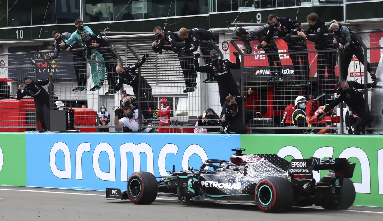 Pembalap Mercedes Lewis Hamilton melintasi garis finis untuk memenangkan F1 GP Eifel di Nuerburgring, Nuerburg, Jerman, Minggu (11/10/2020). Hamilton dengan 91 kemenangannya menyamai legenda F1 Michael Schumacher. (AP Photo/Matthias Schrader, Pool)