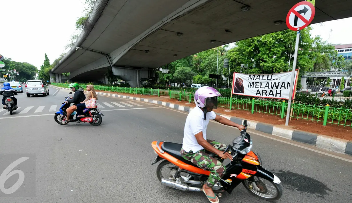 Aksi pemotor melawan arus masih saja terjadi meski sudah terpasang spanduk besar larangan melawan arus di putaran Kalibata, Jakarta, Rabu (16/12/2015). (Liputan6.com/Yoppy Renato)