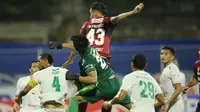 Kiper Persebaya Surabaya, Ernando Ari Sutaryadi, duel udara dengan bek Bali United, Willian Pacheco, pada pekan ke-33 BRI Liga 1 2021/2022 di Stadion I Gusti Ngurah Rai, Denpasar, Jumat (25/3/2022). (Bola.com/M Iqbal Ichsan)