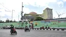 Pengendara melintas saat petugas Penanganan Prasaranan dan Sarana Umum (PPSU) menyelesaikan pembuatan mural di Jalan RE Martadinata, Tanjung Priok, Jakarta Utara, Selasa (24/5/2022). Pembuatan mural di sepanjang Jalan RE Martadinata yang dilakukan oleh petugas PPSU dari 19 kelurahan di Jakarta Utara tersebut dalam rangka menyambut balapan Formula E dan HUT ke-495 Kota Jakarta. (merdeka.com/Iqbal S Nugroho)