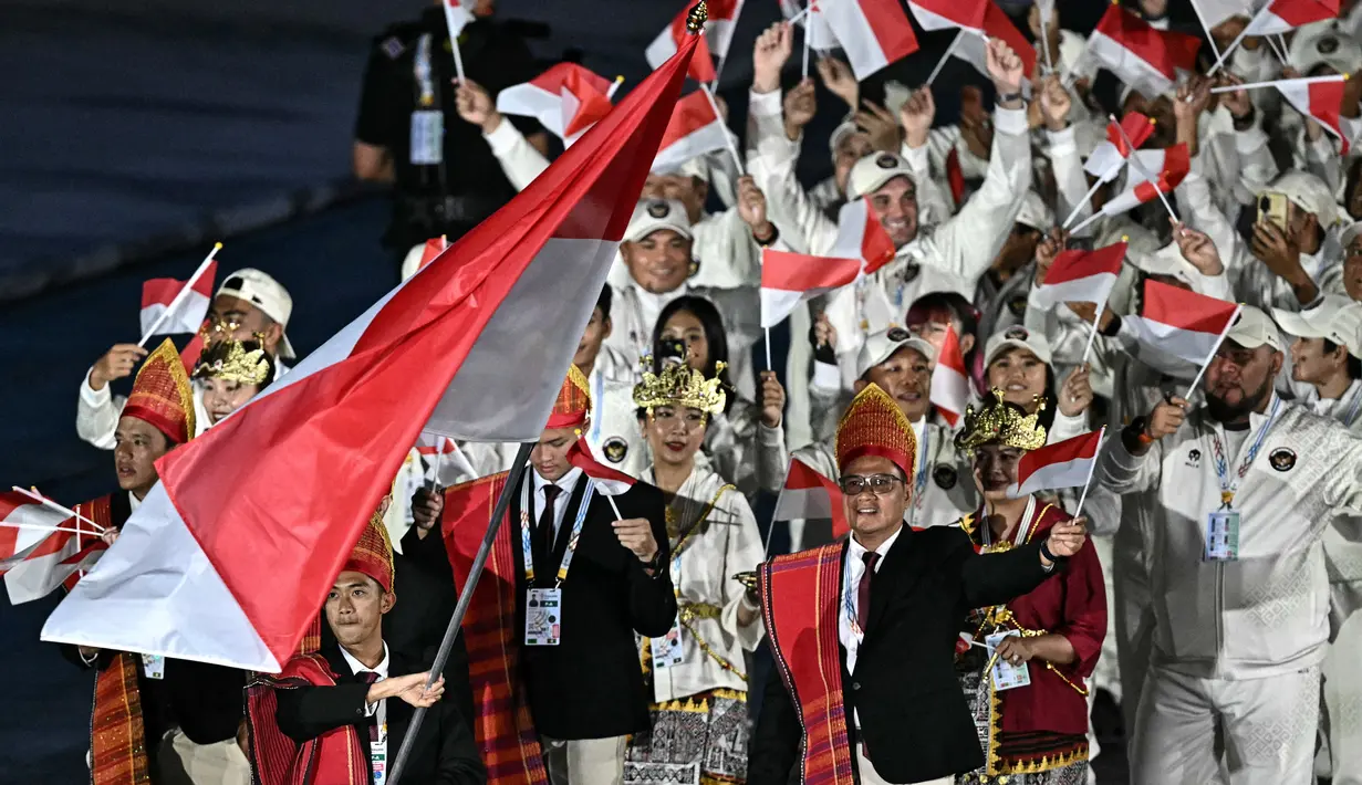 Kontingen Indonesia tampil memukau dengan mengenakan pakaian adat saat upacara pembukaan SEA Games 2025 di Stadion Nasional Rajamangala, Bangkok, pada Selasa (9/12/2025) malam WIB. (AFP/Lillian Suwanrumpha)