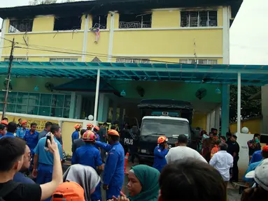 Petugas Pemadam Kebakaran dan Penyelamatan Malaysia berdiri di luar sekolah agama Darul Quran Ittifaqiyah di Kuala Lumpur, Malaysia (14/9). Akibat kebakaran ini 25 orang meninggal dunia. (AFP Photo/Sadiq Asyraf)