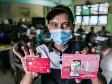 Warga menunjukkan buku tabungan dan ATM usai mengambil Bantuan Sosial Tunai (BST) di SMAN 111, Jakarta, Selasa (19/1/2021). Pemprov DKI Jakarta menyalurkan BST sebesar Rp 300 ribu kepada 1.055.216 KK mulai Januari hingga April 2021. (Liputan6.com/Faizal Fanani)