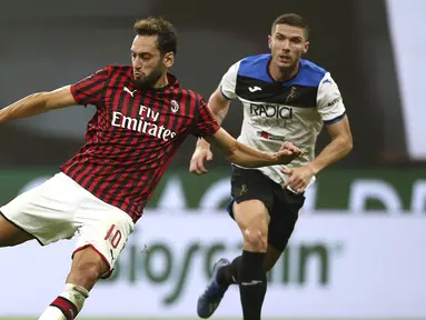 Pemain AC Milan Hakan Calhanoglu (tengah) bersiap melakukan tendangan saat menghadapi Atalanta pada pertandingan Serie A di Stadion San Siro, Milan, Italia, Jumat (24/7/2020). Pertandingan berakhir 1-1. (Spada/LaPresse via AP)