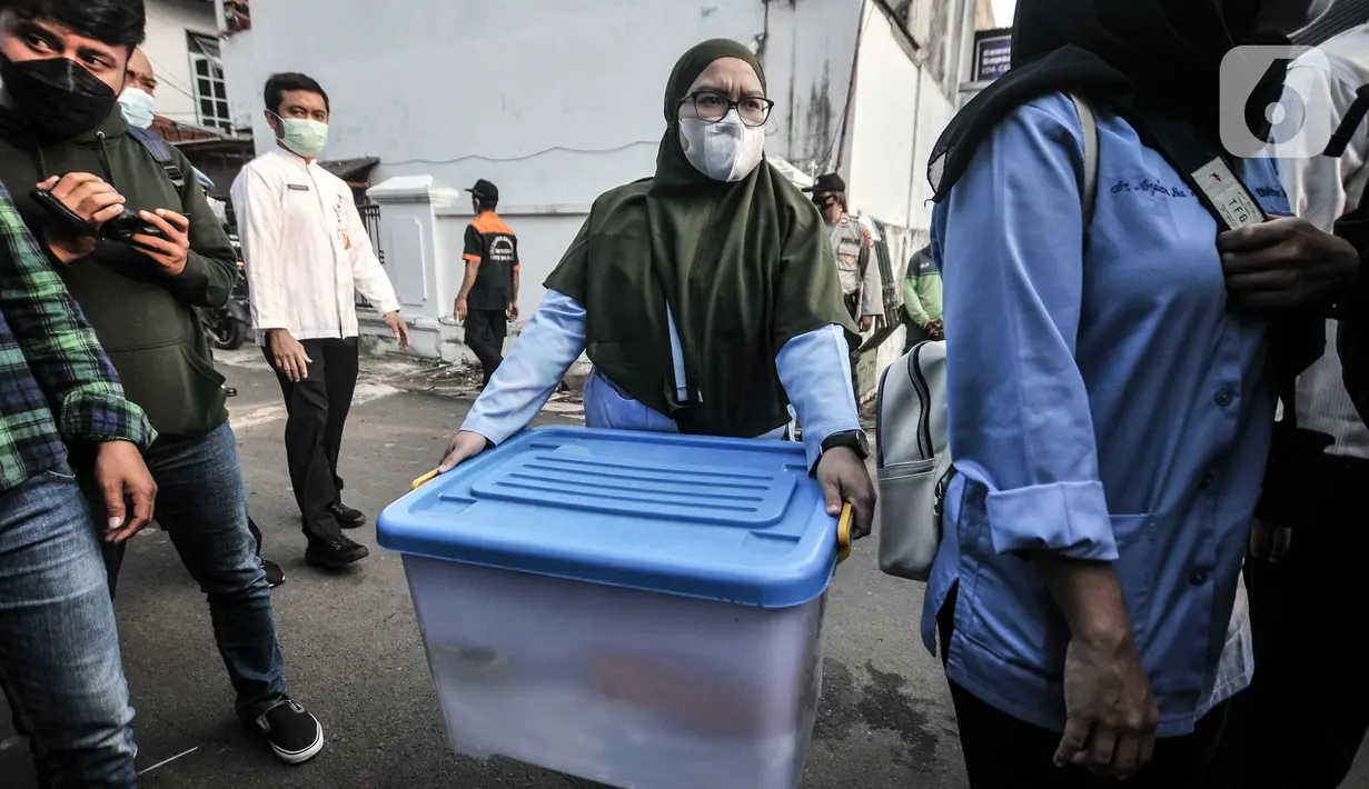 Tim medis membawa boks perlengkapan saat akan mengidentifikasi jenazah Trio di Buaran, Jakarta Timur, Senin (24/5/2021). Jenazah Trio yang meninggal sehari setelah disuntik vaksin AstraZeneca akan menjalani autopsi di RSCM guna memastikan penyebab kematiannya. (merdeka.com/Iqbal S. Nugroho)
