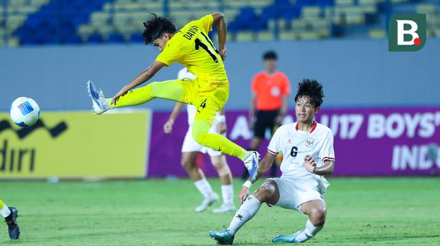 Pemain Timnas Malaysia, Dawud lmran Bin Rozlin, menendang bola saat berebut bola dengan Timnas Indonesia U-17, Girly Andrade Guevara, pada laga kedua Grup A Piala AFF U-17 2026 di Stadion Gelora Joko Samudro, Gresik, Jawa Timur, Kamis (16/4/2026) malam. (Bola.com/M Iqbal Ichsan)