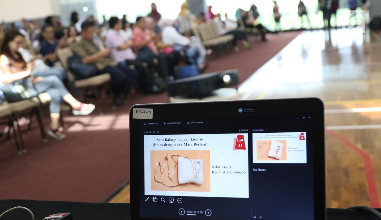 Petugas menunjukkan perhiasan yang dilelang di Gedung Komisi Pemberantasan Korupsi (KPK), Jumat (24/11). KPK melelang barang rampasan dari beberapa perkara kasus korupsi. (Liputan6.com/Immanuel Antonius)