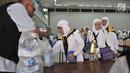 Petugas membagikan air zam-zam untuk jemaah haji Kloter 2 asal Banten di Asrama Haji Pondok Gede, Jakarta, Rabu (29/8). Setiap jemaah mendapatkan lima liter air zam-zam yang dibagikan secara cuma-cuma (Merdeka.com/ Iqbal S. Nugroho)