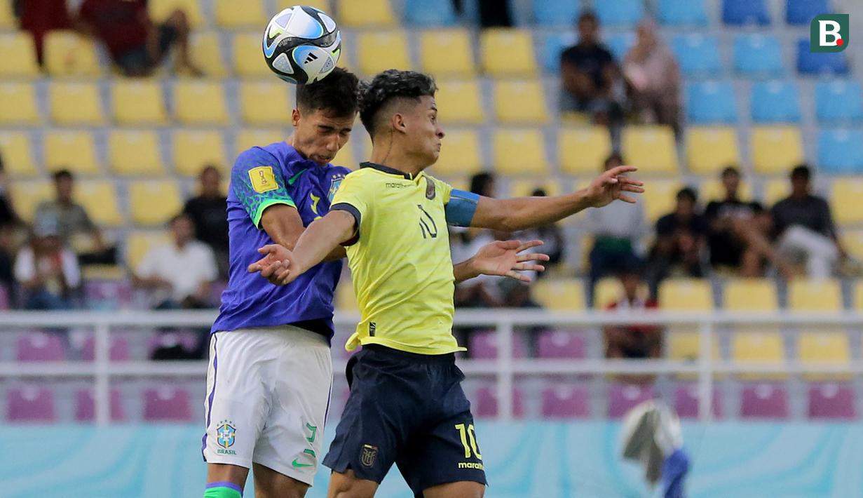 <p>Pemain Timnas Ekuador U-17, Michael Bermudez (kanan) berduel udara dengan pemain Brasil U-17, Vitor Reis dalam pertandingan babak 16 Besar Piala Dunia U-17 di Stadion Manahan, Solo, Senin (20/11/2023). (Bola.com/Arief Bagus)</p>
