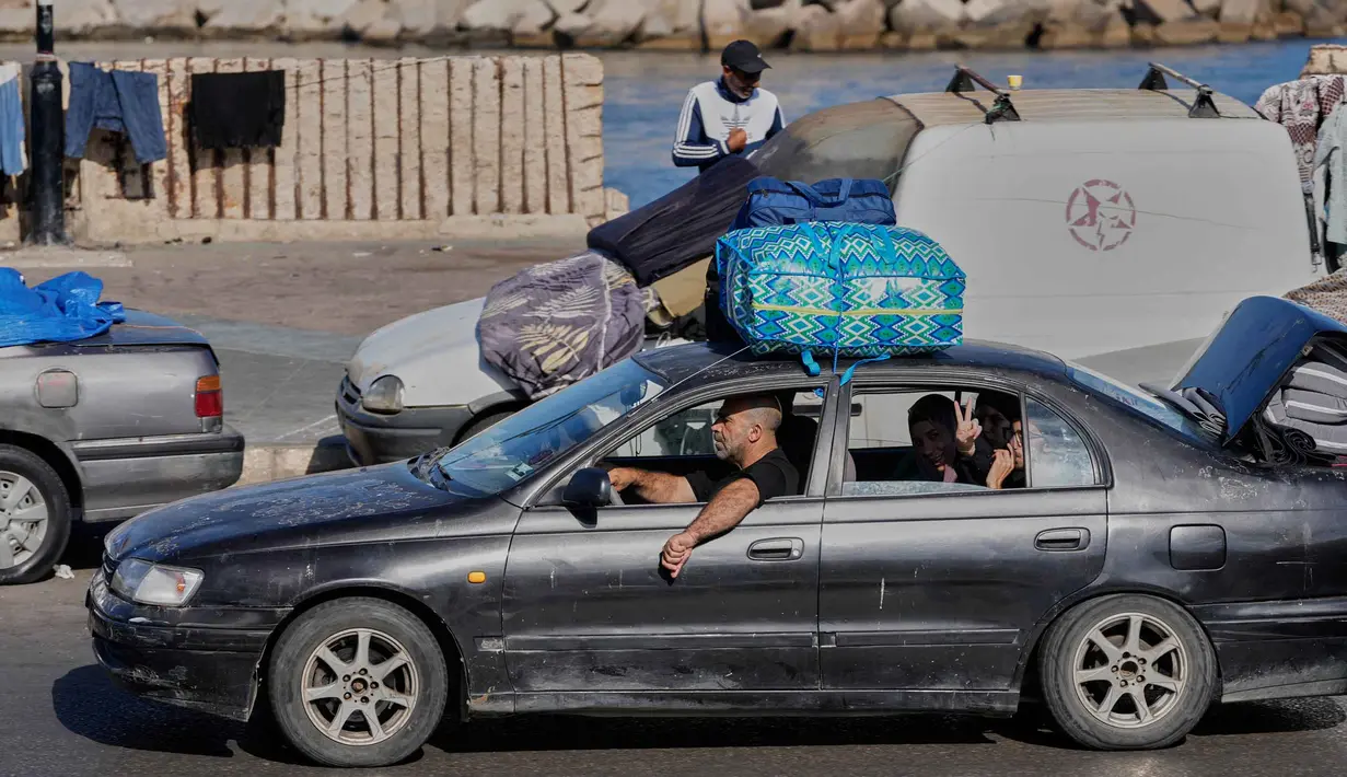 Sebuah keluarga pengungsi dengan barang-barangnya untuk kembali ke desa mereka setelah pengumuman perjanjian gencatan senjata awal antara Amerika Serikat dan Iran, di kota pelabuhan selatan Sidon, Lebanon, Senin 15 Juni 2026. (AP Photo/Mohammed Zaatari)