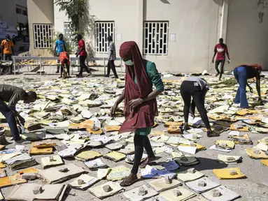 Mahasiswa pengarsipan dan dokumentasi menyaring dokumen yang terbakar di Universitas Cheikh Anta Diop di Dakar pada 09 Juni 2023 dalam upaya untuk menyelamatkannya. (JOHN WESSELS / AFP)