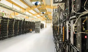 Seorang teknisi melakukan perawatan pada rig pertambangan dari komputer super di dalam pabrik bitcoin 'Genesis Farming' di dekat Reykjavik, Islandia (16/3). (AFP Photo/Halldor Kolbeins)