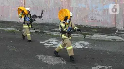 Peserta lomba Jakarta Fire and Rescue Competition 2022 di Pusdiklat Gulkarmat, Ciracas, Jakarta Timur, Senin (21/3/2022). Lomba tersebut untuk menguji ketangkasan dan kecepatan petugas dalam proses penyelematan korban kebakaran di atas gedung dan di air. (Liputan6.com/Herman Zakharia)