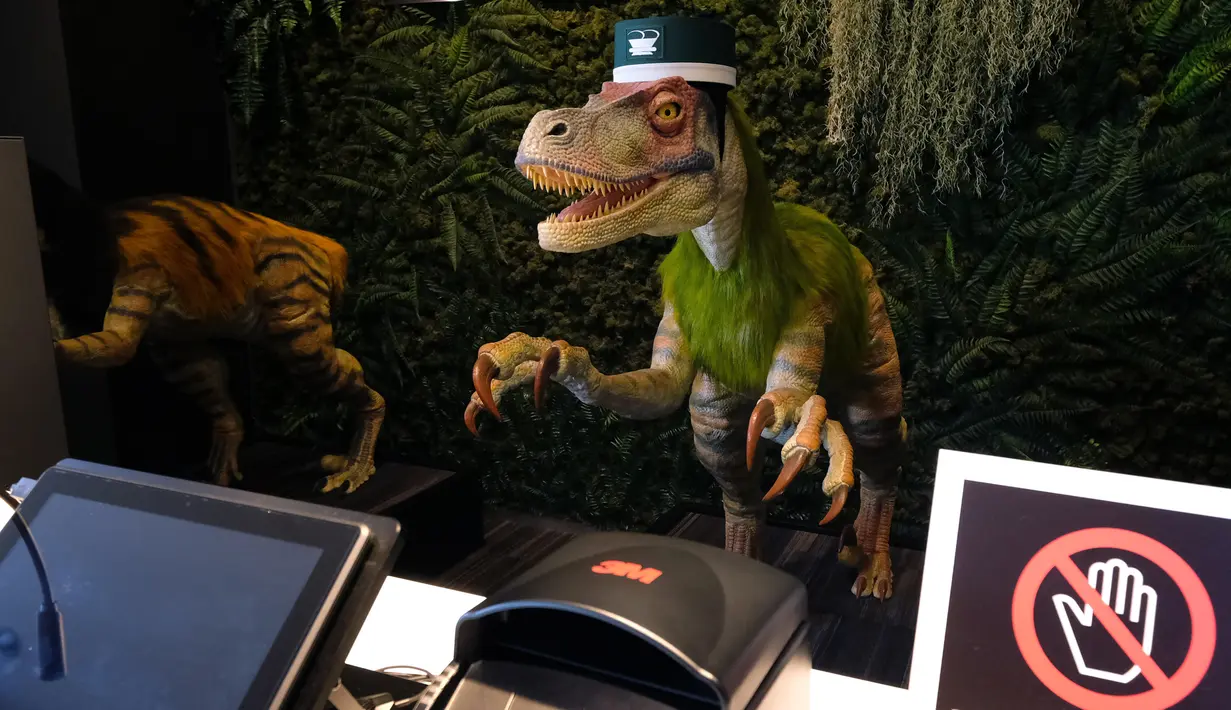 Robot dinosaurus menyambut para tamu dari meja resepsionis Hotel Henn-na di Urayasu, Tokyo, 31 Agustus 2018. Robot dinosaurus besar itu mampu berkomunikasi dengan multibahasa, yaitu Jepang, Inggris, China dan Korea. (AFP/Kazuhiro NOGI)