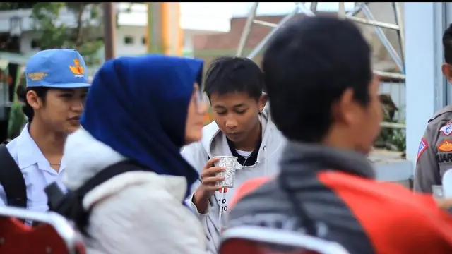 Para pelajar yang terjaring razia Operasi Zebra 2022 di Bilangan Bunderan Suci, Karangpawitan mendapatkan edukasi berlalu lintas yang baik, sambil menikmati sajian kopi hangat melalui pola diplomasi kopdar ala polres Garut. (Liputan6.com/Jayadi Supriadin)