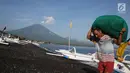 Nelayan membawa hasil tangkapannya dengan latar Gunung Agung di kawasan Amed, Karangasem, Bali, Kamis (7/12). Sepekan terakhir, aktivitas Gunung Agung mulai tampak tenang, meskipun masih status Awas. (Liputan6.com/Immanuel Antonius)