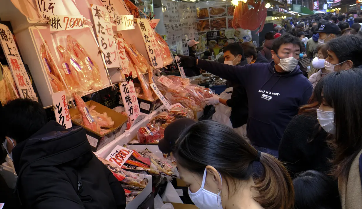 Orang-orang membeli makanan dan perlengkapan untuk merayakan Tahun Baru di distrik perbelanjaan Ueno di Tokyo, Selasa (29/12/2020). Tokyo melaporkan peningkatan kasus virus corona menjelang musim libur tahun baru, dimana biasanya masyarakat yang tinggal di ibu kota akan mudik. (Kazuhiro NOGI/AFP)
