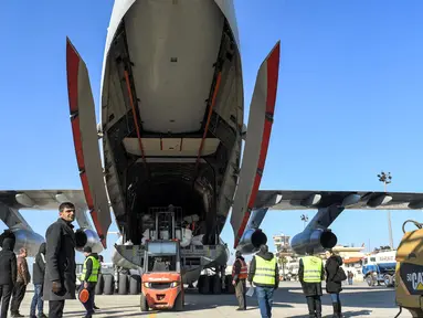 Paket bantuan kemanusiaan yang disediakan oleh Arab Saudi untuk para korban gempa bumi Turki dan Suriah diturunkan dari pesawat angkut Ilyushin Il-76TD di Bandara Internasional Aleppo, Suriah Utara, Selasa (14/2/2023). Proses pencarian dan evakuasi korban hingga kini masih berlangsung. Pada Senin (13/2) tercatat ada 37.357 orang tewas di Turki dan Suriah akibat gempa berkekuatan magnitudo 7,8 tersebut. (AFP)