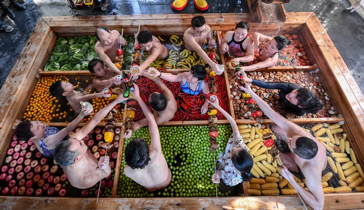 Pengunjung bersulang sambil menikmati berendam di kolam air panas berbentuk hot pot di sebuah hotel di Hangzhou, China, Minggu (27/1). Pemandian air panas itu dirancang untuk mempromosikan gaya hidup sehat menjelang Tahun Baru Imlek. (STR/AFP)