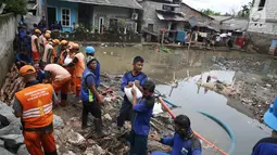 Petugas Suku Dinas Sumber Daya Air dan PPSU mengganjal tanggul yang jebol dengan karung pasir di kawasan Jatipadang, Jakarta, Selasa (12/12). Untuk kesekian kalinya dalam waktu berdekatan, tanggul darurat Kali Pulo jebol. (Liputan6.com/Immanuel Antonius)