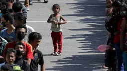 Seorang anak mengantre di antara barisan korban gempa lainnya untuk mendapatkan makanan di lokasi pengungsian, di Kathmandu, Nepal, Senin (4/5/2015).Gempa berkekuatan 7,8 yang meluluhlantakkan Nepal pada 25 April 2015 lalu. (REUTERS/Adnan Abidi)