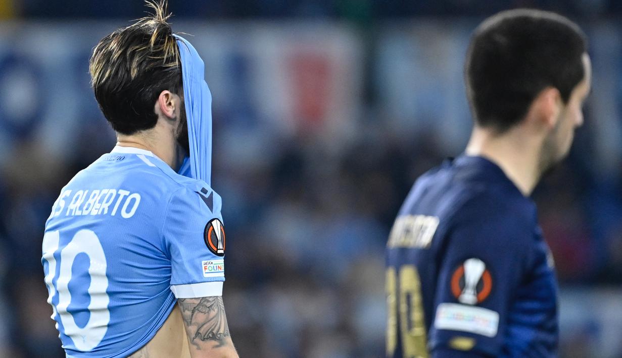 Ekspresi kecewa gelandang Lazio, Luis Alberto (kiri) saat menghadapi tamunya FC Porto dalam laga leg kedua play-off Liga Europa 2021/2022. Bermain imbang 2-2, Lazio gagal lolos ke babak 16 Besar setelah sebelumnya kalah 1-2 di leg pertama. (AFP/Alberto Pizzoli)