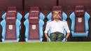 Pelatih Manchester City, Pep Guardiola duduk santai di bangku cadangan saat memantau latihan ringan sebelum laga Aston Villa melawan Manchester City di pekan keenam Liga Inggris 2022/2023. (AFP/Geoff Caddick)
