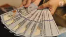 Petugas menunjukkan uang dolar AS di gerai penukaran mata uang di Ayu Masagung, Jakarta, Senin (13/8). Pada perdagangan jadwal pekan, senin (13/08). Nilai tukar rupiah terhadap dolar AS menyentuh posisi tertingginya Rp 14.600. (Merdeka.com/Arie Basuki)