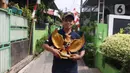 Warga membawa patung burung garuda pancasila di Kampung Pancasila, Karang Tengah, Kota Tangerang, Selasa (1/6/2021). Sejumlah kegiatan diadakan warga, Komunitas Taman Potret dan TNI ini untuk memperingati Hari kelahiran Pancasila. (Liputan6.com/Angga Yuniar)