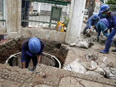 Petugas Sudin SDA DKI Jakarta membuat sumur resapan dangkal di kawasan Utan Kayu, Rabu (18/11/2020). Pengerjaan sumur resapan dangkal tersebut untuk bisa menyerap air sehingga membantu mengurangi beban di Kali Cipinang ketika memasuki musim penghujan. (Liputan6.com/Faizal Fanani)