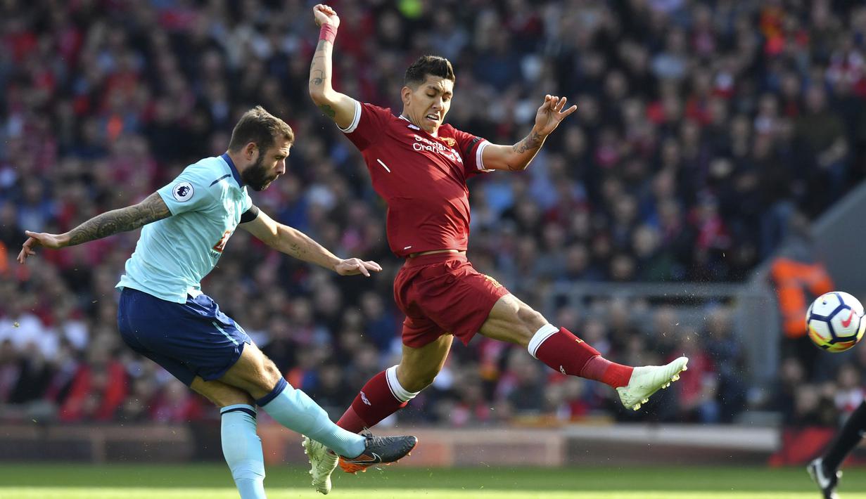 Pemain Liverpool, Roberto Firmino (kanan) mencoba menghalau bola sepakan pemain AFC Bournemouth, Steve Cook pada lanjutan Premier League di Anfield stadium, Liverpool,(14/4/2018). Liverpool menang 3-0. (Anthony Devlin/PA via AP)