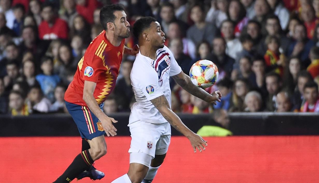 Gelandang Spanyol, Sergio Busquets, berusaha menjaga striker Norwegia, Joshua King, pada laga Kualifikasi Piala Eropa 2020 di Stadion Mestalla, Valencia, Sabtu (23/3). Spanyol menang 2-1 atas Norwegia. (AFP/Jose Jordan)