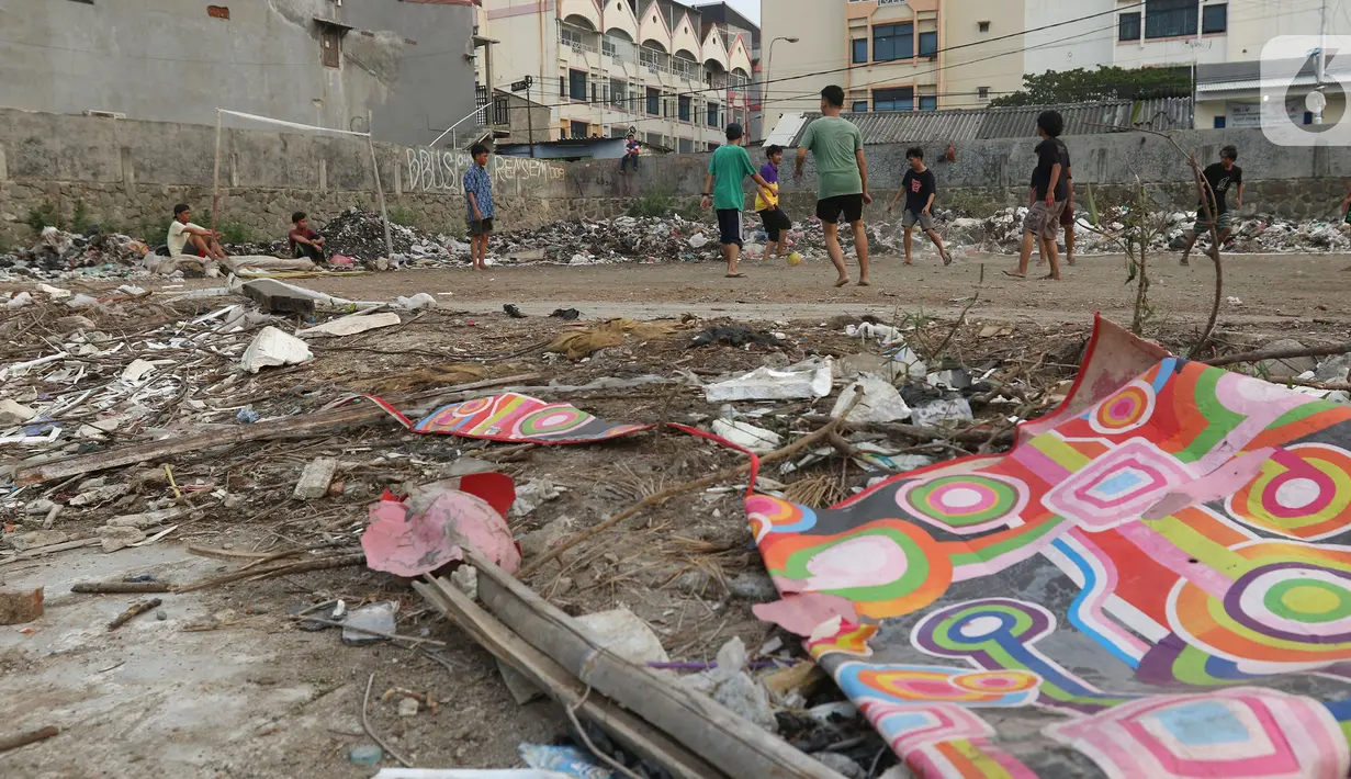 Sejumlah warga bermain sepak bola di antara tumpukan sampah di kawasan Penjaringan, Jakarta, Jumat (1/11/2019). Minimnya lahan bermain di Jakarta membuat warga bermain sepak bola di sekitar tumpukan sampah. (Liputan6.com/Herman Zakharia)