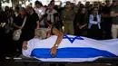 Dan kesedihan terus merebak di seluruh Israel, ketika para ibu menguburkan anak-anak mereka, bendera dan bunga berjejer di lebih banyak kuburan. (AP Photo/Francisco Seco)