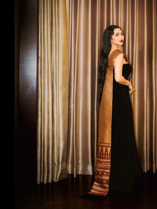 Ulos tersebut jadi aksen one shoulder pada strapless dress dan rok slit yang menawan [@arieltatum]