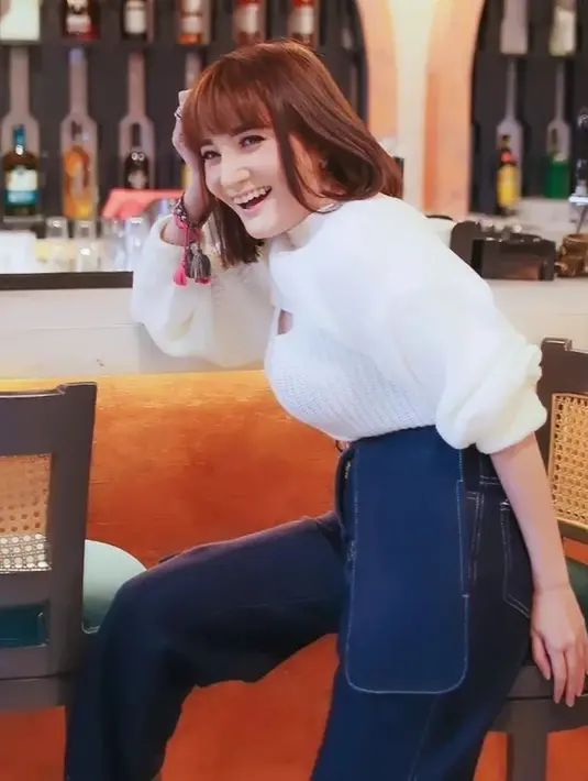 Perpaduan busana berwarna putih dengan celana denim memang tidak pernah salah digunakan. Wanita yang segera melepas masa jandanya ini terlihat memsona dengan sweater putih serta denim dengan detail unik. (Liputan6.com/IG/@kikiamaliaworld)