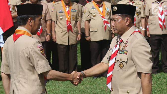 Presiden Joko Widodo (Jokowi) berjabat tangan dengan Komjen Pol (Purn) Budi Waseso saat pelantikan Ketua Kwartir Nasional Gerakan Pramuka masa bakti 2018-2023 di halaman Istana Merdeka, Jakarta, Kamis (27/12). (Liputan6.com/Angga Yuniar)