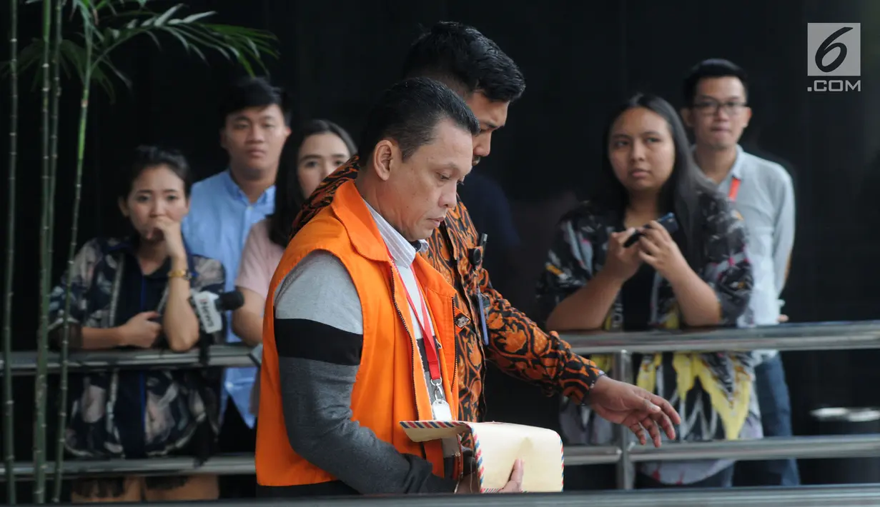 Staf PT Industri Telekomunikasi Indonesia (Inti) Taswin Nur menutupi borgol di tangannya dengan map cokelat saat akan melaksanakan salat, Gedung KPK, Jakarta, Jumat (16/8/2019). Nur diperiksa sebagai tersangka terkait aliran suap proyek pengadaan sistem penanganan bandara. (merdeka.com/Dwi Narwoko)