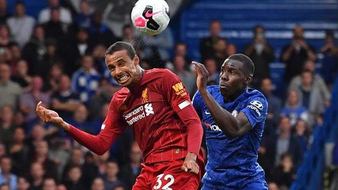 Bek Liverpool, Joel Matip, duel udara dengan bek Chelsea, Kurt Zouma, pada laga Premier League di Stadion Stamford Bridge, London, Minggu (22/9). Chelsea kalah 1-2 dari Liverpool. (AFP/Olly Greenwood)