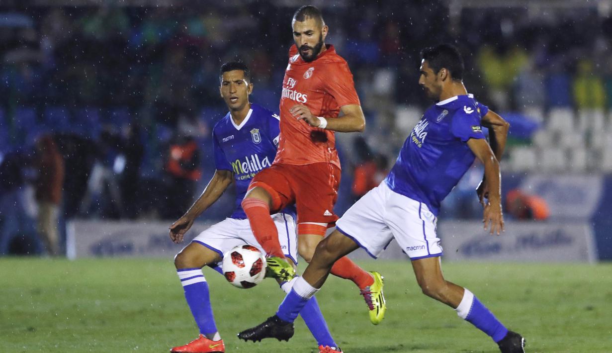 Striker Real Madrid, Karim Benzema, berusaha melewati pemain UD Melilla pada laga Copa del Rey di Stadion Alvarez Claro, Melilla, Rabu (31/10/2018). Real Madrid menangan 4-0 atas UD Melilla. (AP/Javier Gandul)