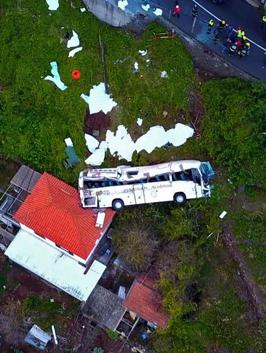 Kondisi sebuah bus pariwisata berisi rombongan turis dari Jerman yang terguling di Kota Canico, Pulau Madeira, Portugal, Rabu (17/4). Kecelakaan terjadi di mana bus yang mengangkut 55 otang turis terguling saat membelok dari jalan sempit yang curam. (STRINGER / AFP)