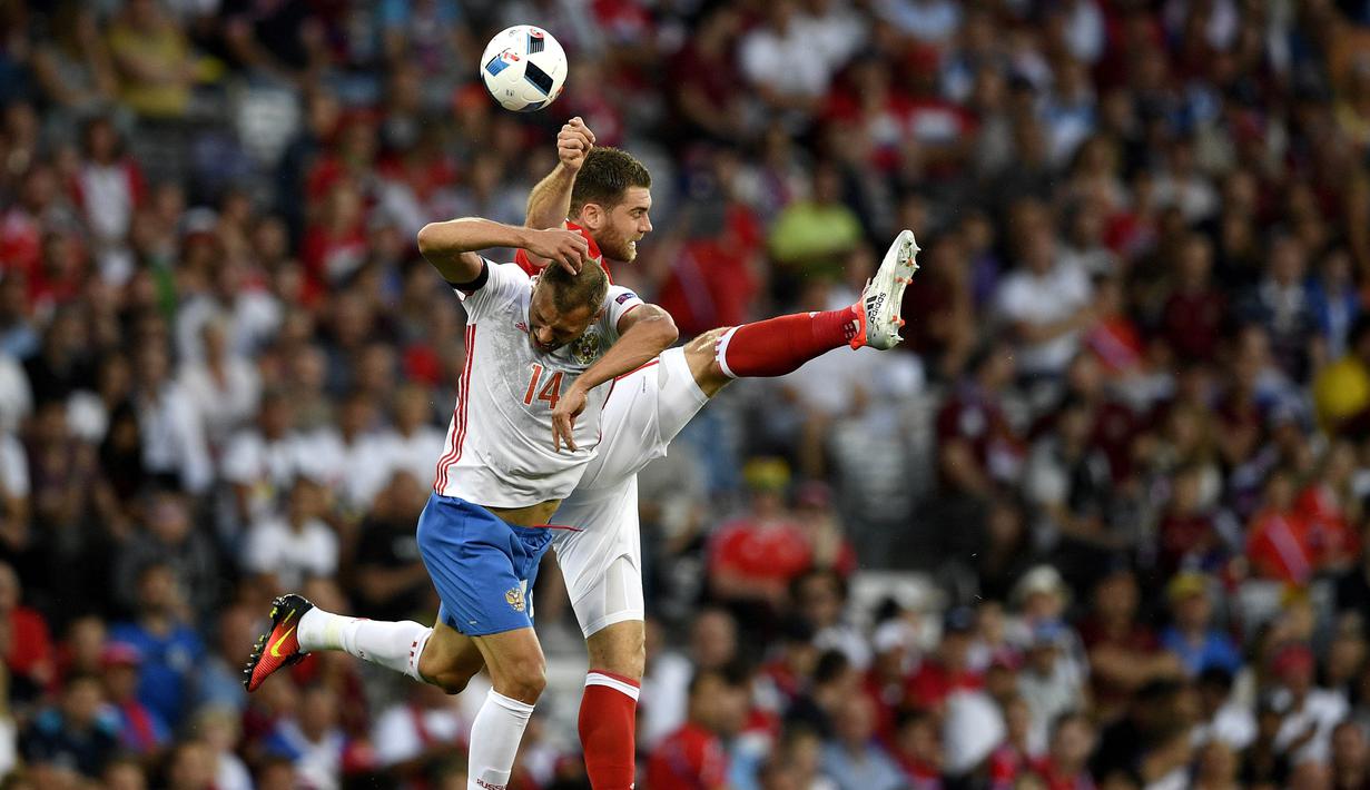 Pemain Rusia, Vasily Berezutskiy (kiri) berduel udara dengan pemain Wales, Sam Vokes pada laga grup B Euro cup 2016 di Stadion Municipal, Toulouse, Selasa (21/6/2016) dini hari WIB. Wales menang 3-0. (AFP/Martin Bureau)