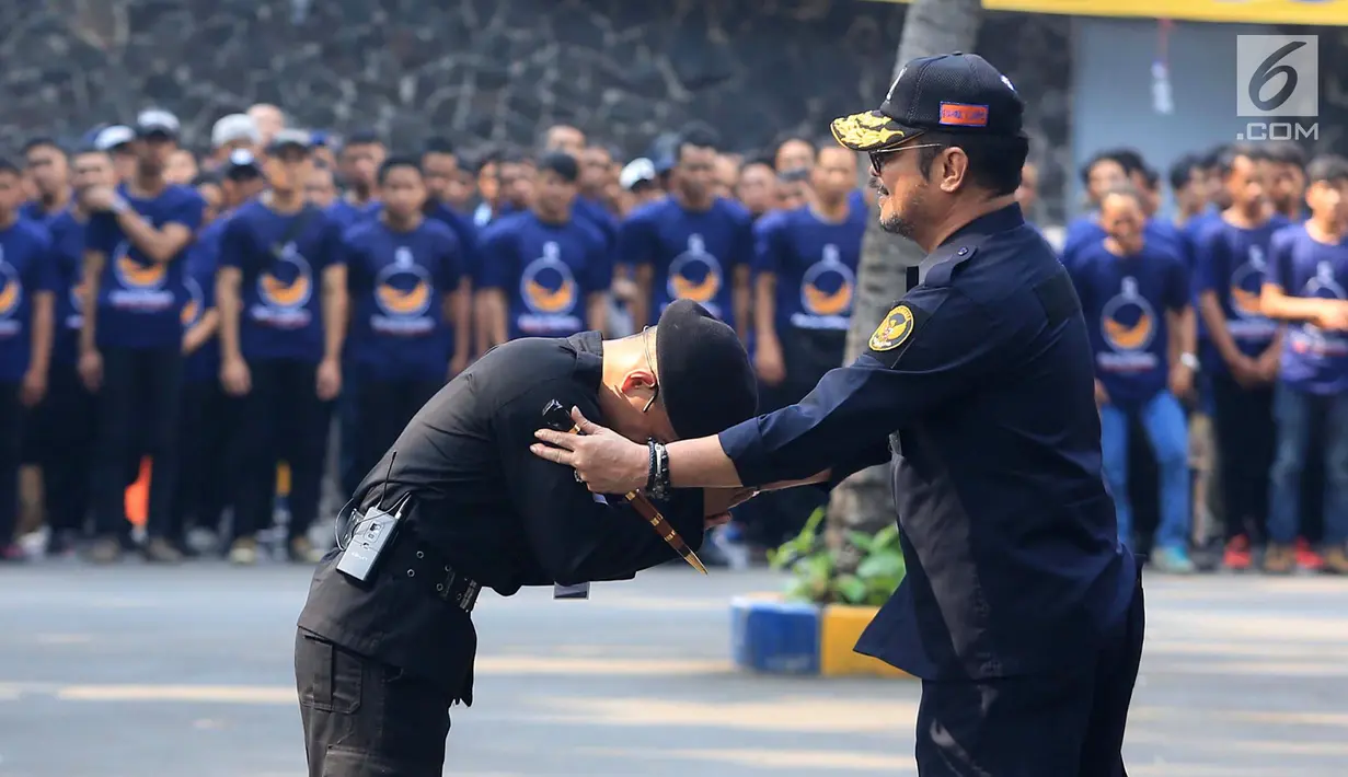 Ketua DPP Partai NasDem Bidang Otda Syahrul Yasin Limpo (kanan) menyalami anggota saat memimpin upacara peringatan Hari Kesaktian Pancasila di Jakarta, Senin (1/10). Upacara ini diikuti oleh Keluarga Besar Partai Nasdem. (Liputan6.com/Herman Zakharia)
