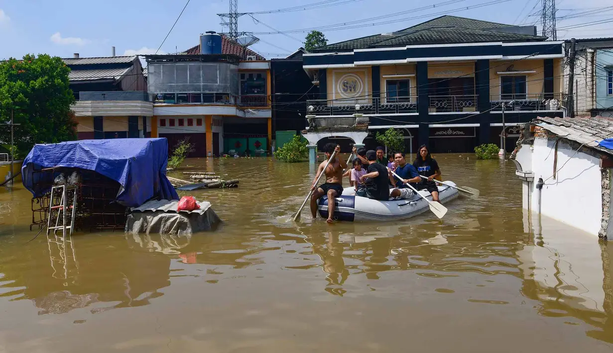 Para pemuda mengevakuasi penduduk saat banjir menggenangi area RT 02/06, Kelurahan Petir, Kota Tangerang, Banten, Selasa (8/7/2025). (merdeka.com/Arie Basuki)