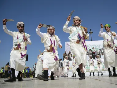 Sejumlah pengantin pria menari dengan mengenakan pakaian tradisional saat nikah massal di Sanaa, Yaman, 2 Desember 2021. Houthi mengadakan nikah massal untuk ribuan pasangan. (AP Photo/Hani Mohammed)