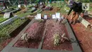 Sardi, pengurus makam membersihkan makam Vanessa Angel dan Bibi Ardiansyah di TPU Taman Makam Islam Malaka Blok D, Pesanggrahan, Jakarta, Senin (7/02/2022). H. Faisal menginginkan makam Vanessa Angel tetap bersebelahan dengan putranya, Bibi Andriansyah. (Liputan6.com/Fery Pradolo)