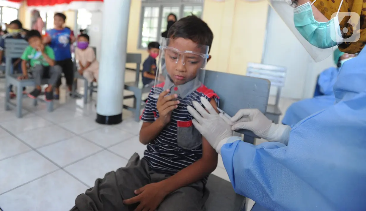 Petugas kesehatan menyuntikkan vaksin tetanus difteri ke siswa kelas 1 di SDI Al Hidayah, Cinere, Depok, Jumat (20/11/2020). Program imunisasi kepada pelajar di Kota Depok terus berjalan guna menjaga kesehatan anak dan meningkatkan imunitas tubuh di masa pandemi COVID-19. (merdeka.com/Arie Basuki)